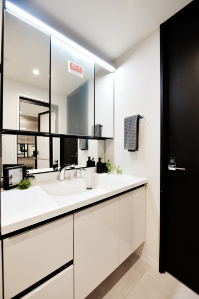 大きな三面鏡付きで身だしなみも整えやすい洗面台です。洗面台の横にはトールキャビネットも設置しましたので、リネン類や小物類もたっぷりと収納でき、スッキリとした空間を保てます。