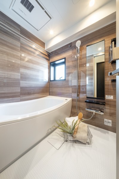 光沢のある木目調パネルが高級感を漂わせるバスルームです。ゆったりとしたバスタブで毎日のお風呂時間を心ゆくまでお楽しみいただけます。