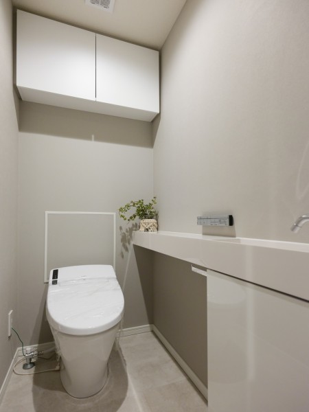 安らぎが宿るレストルームです。手洗い場やカウンターを備え付け、清潔感と使いやすさを考慮した空間です。吊戸棚を設けたので、掃除用品やペーパー類のストックがすっきりと収納いただけます