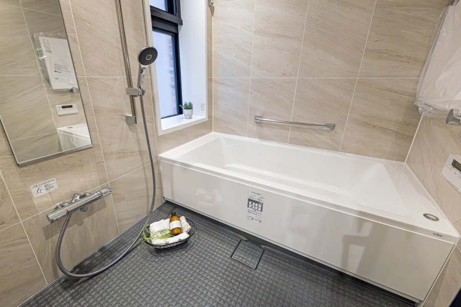 淡い色味のパネルに囲まれ、やすらぎとあたたかみを感じられるバスルームです。窓が付いているので自然な明かりを取り込むことができ、明るく開放的な空間です。