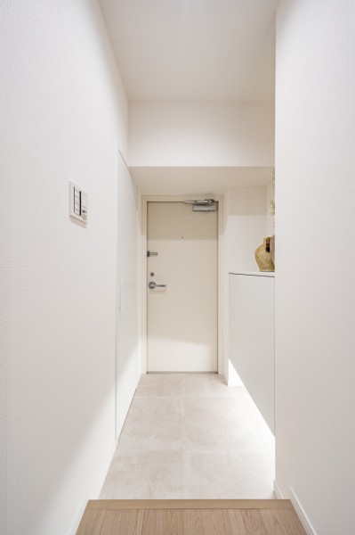 住まいの顔となる玄関は明るいホワイトカラーで仕上げました。フットライトが足元を照らし、明るい空間が出迎えてくれます。収納も設置したので、ブーツや日用品などもたっぷり収納できそうです。