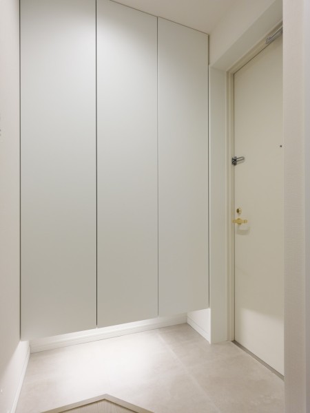 清潔感のある玄関は、フットライトからのびる光が足元を優しく包み込みます。天井までの高さがあるシューズボックスを備え付けたので、玄関をすっきり綺麗に保てます。