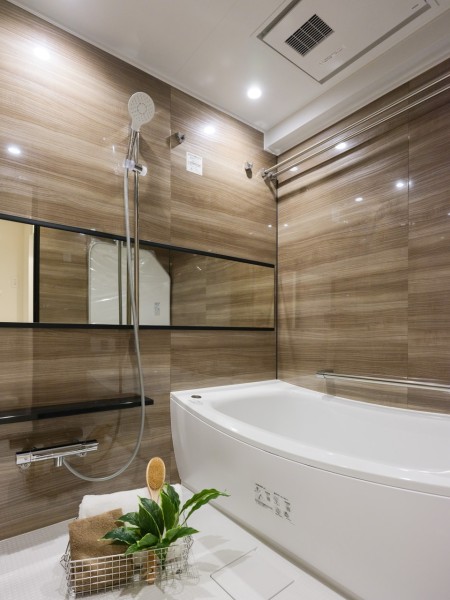 光沢のある木目調パネルが高級感を醸し出すゆったりとしたバスルームです。美しいカーブと全身を包み込むような入浴感が特長の浴槽です