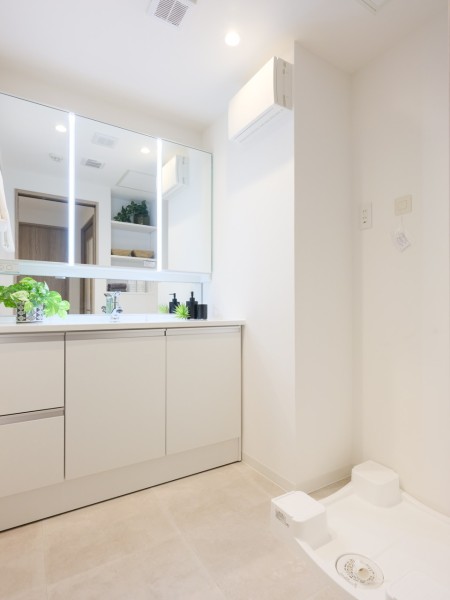 白を基調としたスタイリッシュなデザインの洗面化粧台は、収納豊富な三面鏡タイプ。カウンターとボウルが一体となっているのでお手入れもしやすいです。