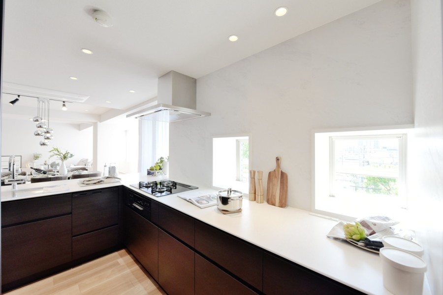 このお部屋に合わせて造作したL字型のシステムキッチンです。窓もあり、明るく開放的な空間で、快適に家事が出来ます。パントリーや収納などをたっぷりと造り付けましたので、収納家具を置かなくても充分収納出来ます。