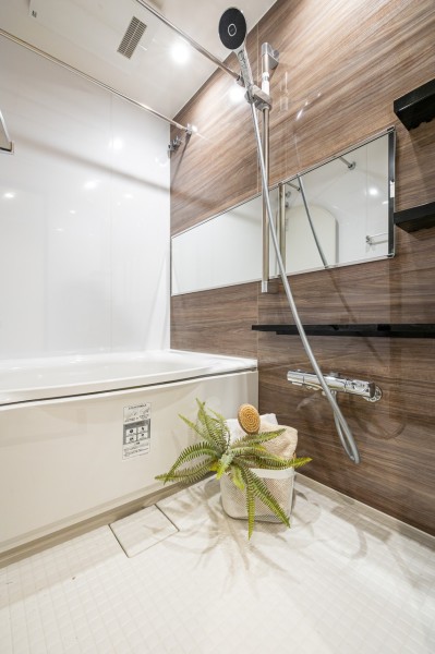 木目調のパネルが、くつろぎと高級感を醸し出します。浴室をより広く見せる効果がある横長ミラーを採用。くつろぎのリラクゼーションタイムを心行くまでお楽しみいただけます。