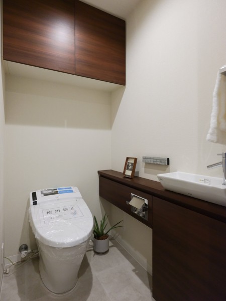 LIXIL製洗浄便座付タンクレストイレを新規設置。手洗い場や収納に便利なカウンターも備え付けです。清潔感と使いやすさを考慮した空間です。