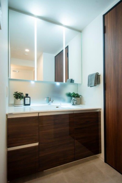 空間に美しく溶け込む飽きのこないシンプルなデザインの洗面化粧台です。三面鏡の裏側や足元のキャビネットなど、収納豊富で実用的な洗面空間です。