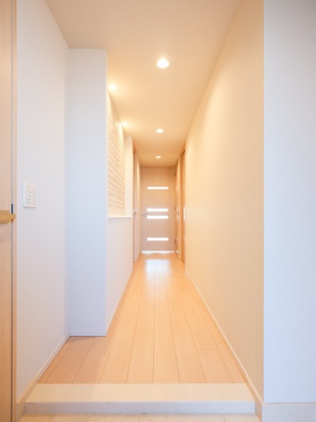 玄関からリビングダイニングキッチンへ続く廊下です。廊下の壁のニッチには脱臭といった機能性とデザイン性を兼ね備えたエコカラットを採用しました