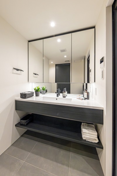 洗面化粧台は、キッチンと同じくオリジナルデザインで上品さが宿ります。大きな三面鏡で身だしなみのチェックもしやすい洗面台です。三面鏡裏が収納で、小物類が多い洗面まわりもすっきり整頓できます。