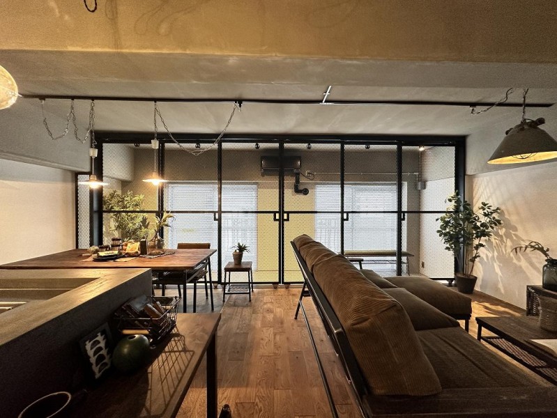 リビングからバルコニー方向の眺めです。バルコニー掃出し窓とインナーバルコニーの境にメッシュのフェンスを設置しています。光が透過して緩やかに空間を仕切っています。