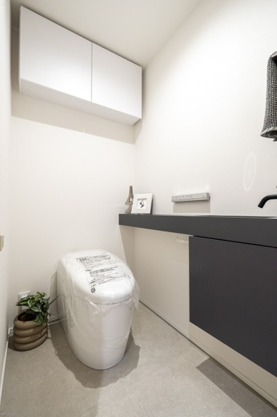 毎日使う場所だからこそ、清潔感と使いやすさを考慮した空間です。洗練されたデザインのタンクレスを採用。上部には収納に便利な吊戸棚を備え付けました。