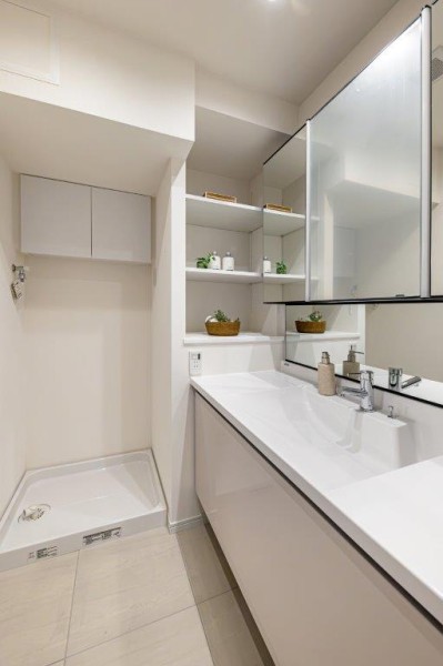 身支度の時間をも快適に彩る、美しく空間に溶け込む洗面化粧台です。洗濯機置場の上には便利な棚を備え付けました。