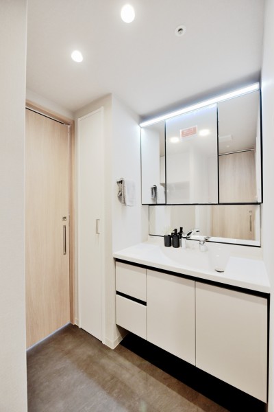 タッチレススイッチで手を触れずに照明のオンオフが出来る便利な洗面台です。キッチンからも出入りが可能な回遊動線となっており、家事がはかどりそうです。洗面横には大容量の収納を設置しました。