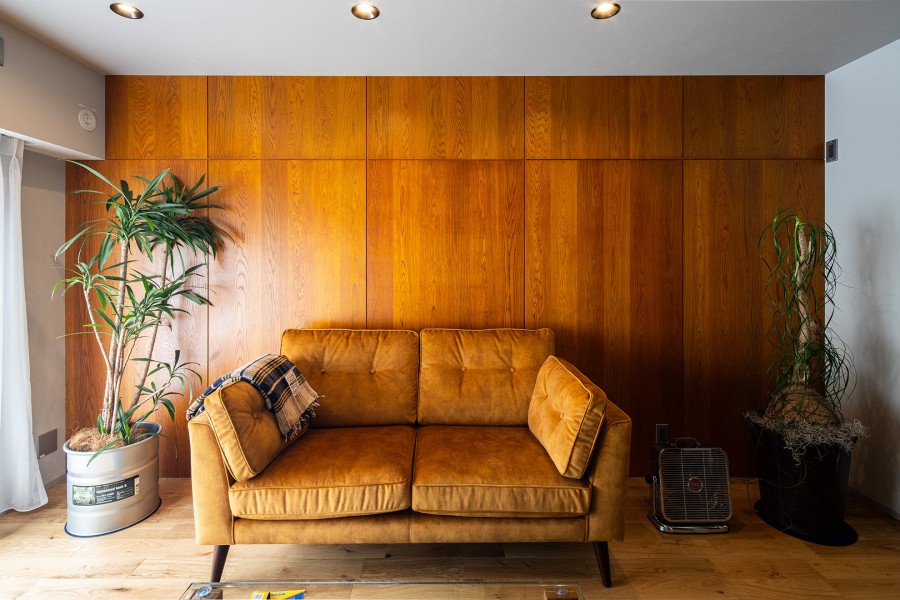 大判で表情豊かな木目と艶感が美しいウッドパネルはダルトンホームのオリジナル建材。調光も可能なダウンライトの光がパネルにあたり、重厚感のある落ち着いた空間に。