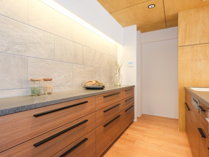 キッチンとお揃いのスライドストッカーを備え付けました。壁面に重厚なクォーツサイトをモチーフにしたカバラストンのタイルを取り入れ、毎日の家事の時間もより明るく、上質な時間に感じられるように仕上げました。