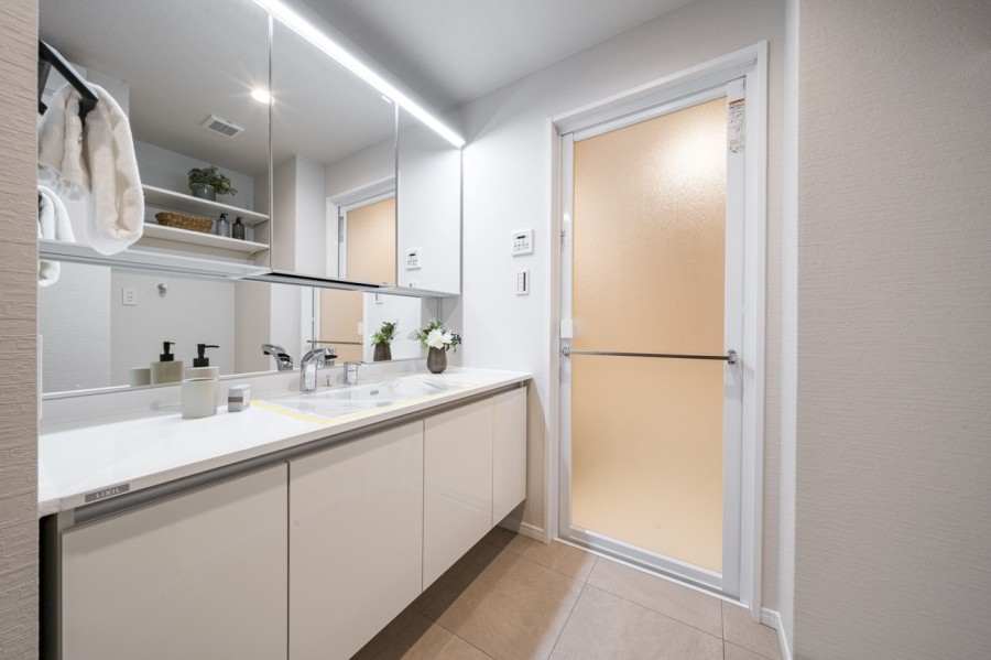 身支度の時間をも快適に彩る、美しく空間に溶け込む洗面化粧台です。洗面台には隣にはタオルなどの収納に便利な棚を備え付けております。