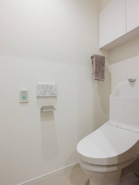 上品さが宿るホワイト基調のレストルームです。上部には収納に便利な吊戸棚を備え付けました。毎日使う場所だからこそ、清潔感と使いやすさを考慮した空間です。