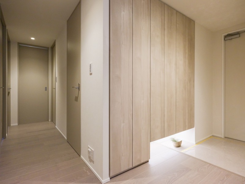 清潔感と格調高さが溢れる玄関には、天井までの高さのシューズボックスを備え付けました。足元のフットライトが広がる明るい空間です。