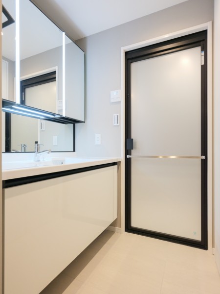 空間に美しく溶け込むスタイリッシュなデザインの洗面化粧台は、収納豊富な三面鏡タイプ。入浴後の豊かな時間を演出し、心からくつろげるプライベートスペースの洗面化粧室です。