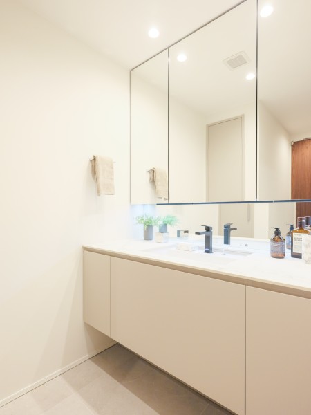 入浴後の時間をも快適に彩る、明るくホテルライクな洗面室です。大きな三面鏡付きでカウンターも広い洗面化粧台やリネン庫など、使い勝手の良い空間に仕上げました。
