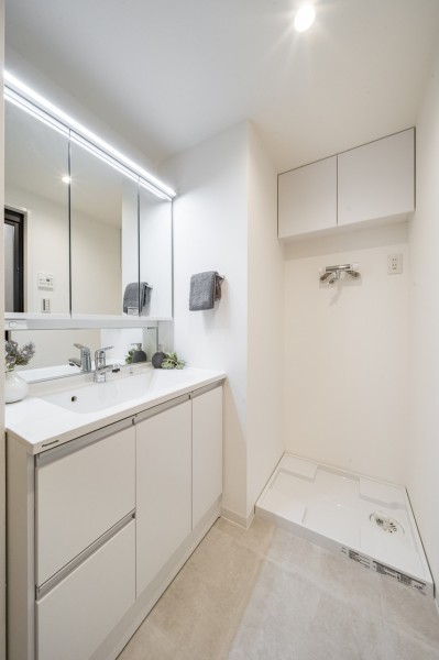 身支度の時間をも快適に彩る、美しく空間に溶け込む洗面化粧台です。洗濯機置場の上には便利な吊戸棚を備え付けました。