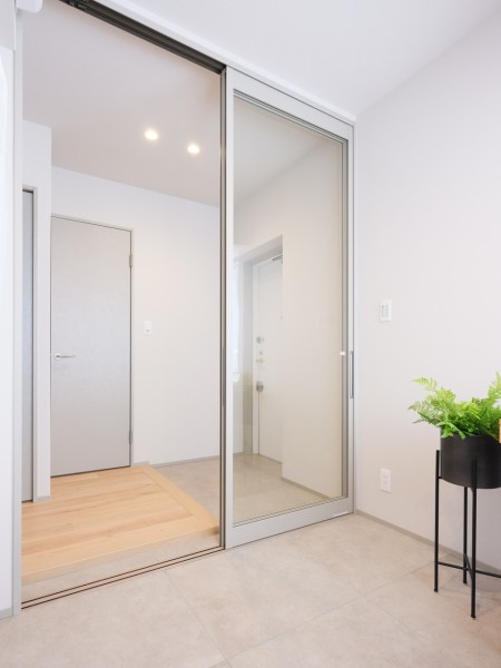 住まいの顔となる玄関スペースには洋室2の窓からの陽光が降り注ぎます。洋室2と同様のフラットタイルを採用し、シームレスな空間へと演出します。