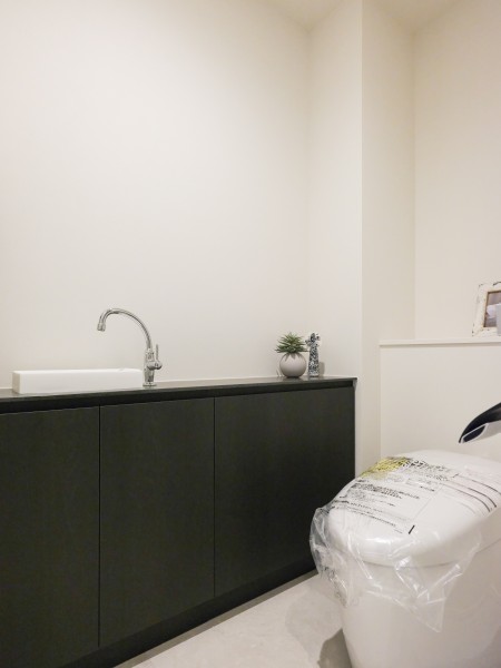 スマートなタンクレストイレを採用したレストルームです。サイドには備品収納が可能な手洗いカウンターを設けました。