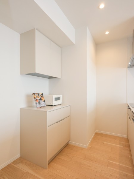 背面にはキッチンとお揃いのカップボードがあり、収納や作業スペースが豊富です。快適な家事動線が確保されたオープンキッチンです。