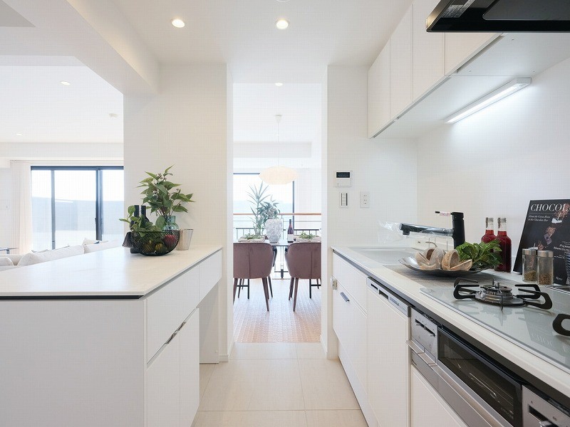 お部屋の雰囲気に溶け込む、インテリアの一部のようなLIXIL製のシステムキッチンです。キッチン背面には収納豊富でカウンタースペースも広いカップボードがあります。