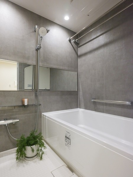 グレートーンの壁がスタイリッシュな印象を与えるバスルーム。機能美と心地よさを両立しています。