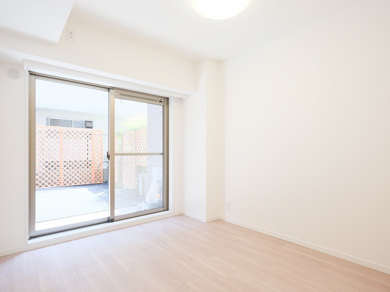 南向きで明るく、心地よい光が差し込む洋室1です。テラスと専用庭に面しており、開放感とプライベート感のある空間です。