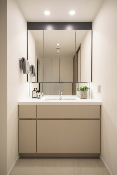 洗面化粧台は、キッチンと同じく田中工藝製で上品さが宿ります。大きな三面鏡で身だしなみのチェックもしやすい洗面台です。三面鏡裏が収納で、小物類が多い洗面まわりもすっきり整頓できます。