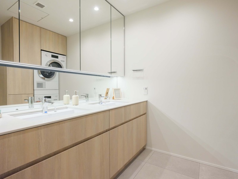 洗面化粧台は、キッチンと同じく田中工藝製で上品さが宿ります。大きな三面鏡で身だしなみのチェックもしやすい洗面台です。三面鏡裏が収納で、小物類が多い洗面まわりもすっきり整頓できます。