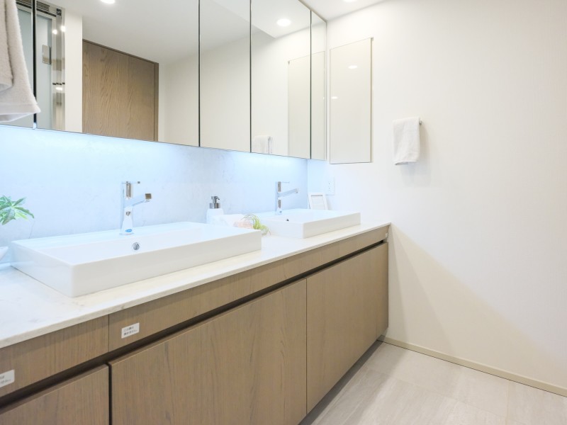 ダブルボウルの洗面台は大きな鏡で身だしなみも整えやすく、朝の慌ただしい時間帯も快適です。タオルや着替えなどを収納できるリネン庫もあります。