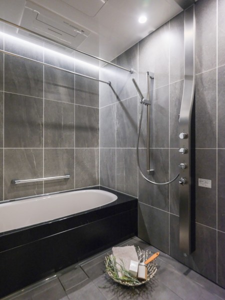 重厚でラグジュアリーな印象のホテルライクな癒しのバスルームです。間接照明が映えるブラック基調のユニットバス。オーバーヘッドシャワー付きで、上質なリラックスタイムを演出します。