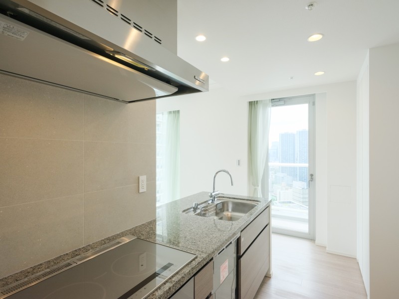 コンロ前のみ壁付け、ふき汚れもさっと拭き取れるIHコンロを新規設置しています。シンク側の右手にはバルコニーにつながっているため換気がしやすく、採光性も高い設計です。